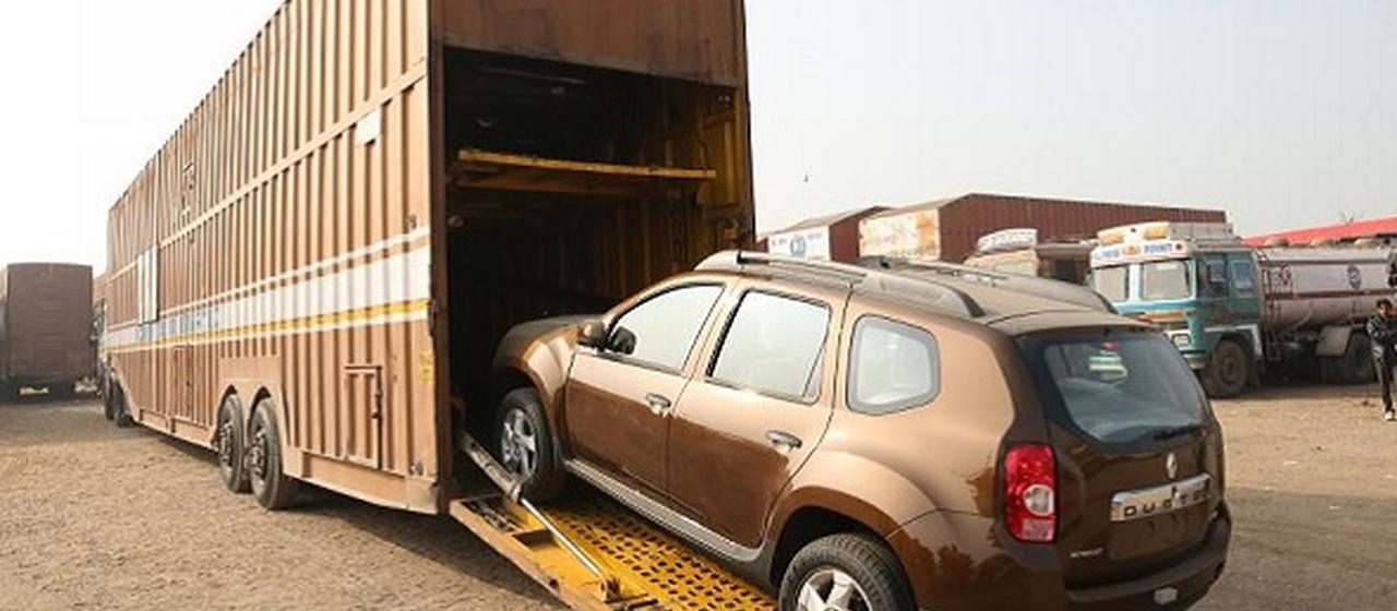 Car being loaded into an enclosed car carrier