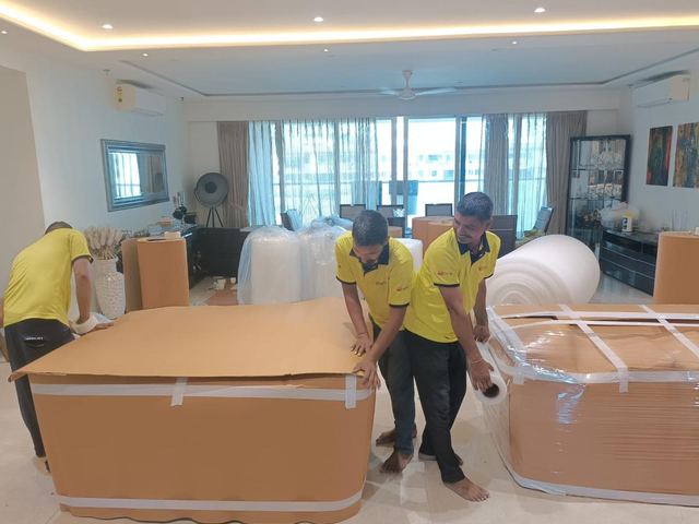 Team wrapping furniture with corrugated sheets