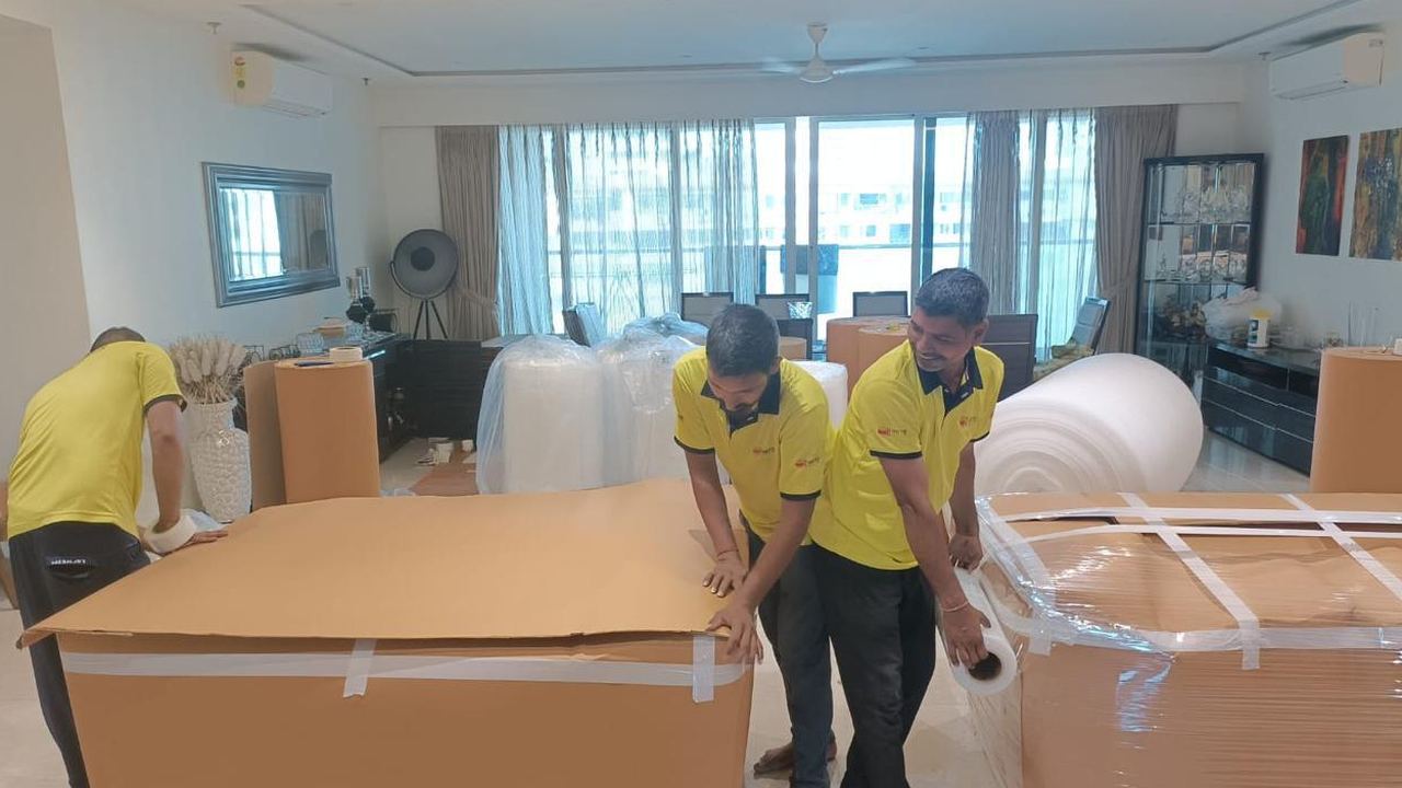 PN Writer Relocation team wrapping furniture with corrugated sheets in a customer's home
