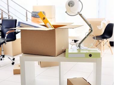 Office desk with packed moving cartons